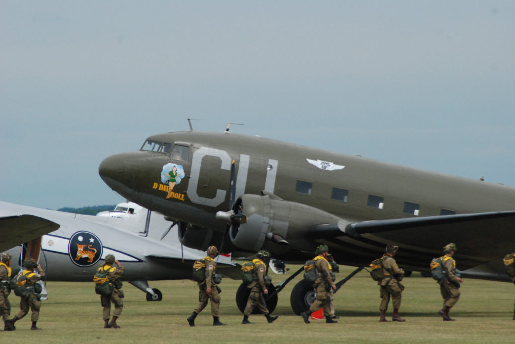 Parachutists cross Duxford grass to board Commemorative Air Force's C-53 squadron D-Day Doll on June 5th 2019.